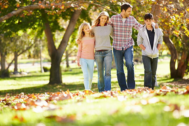 Famille marchant dans les feuilles