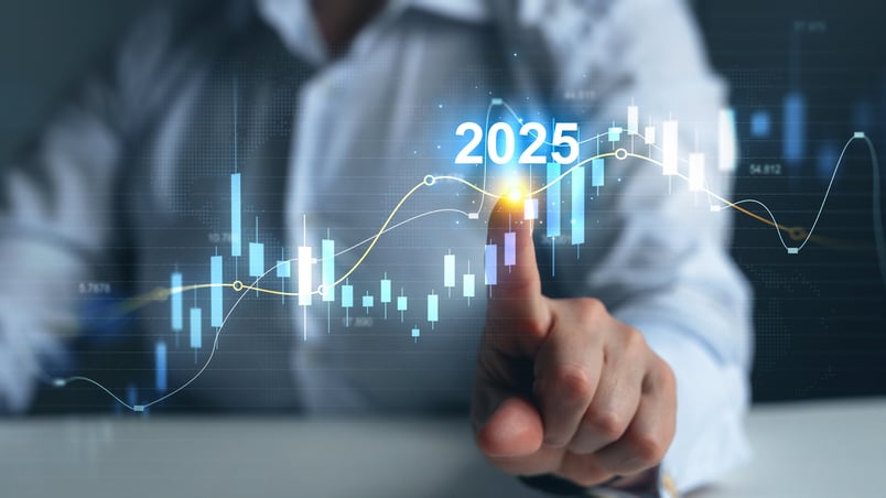 A holographic chart with a hand pointing at the year "2025".