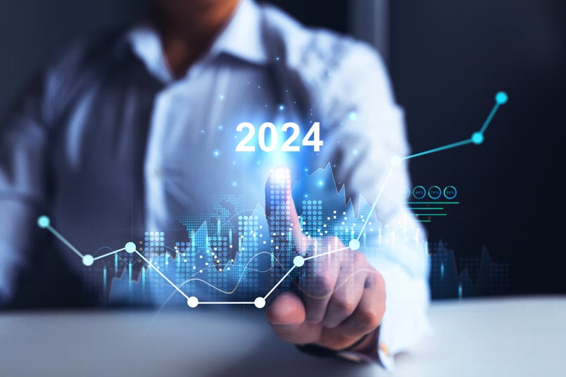 Image of a man pressing on the year “2024” on a holographic line graph. 