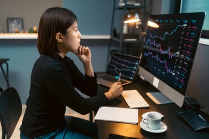 Woman looking at computer with graphs.