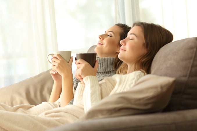 Two young women sitting on a sofa