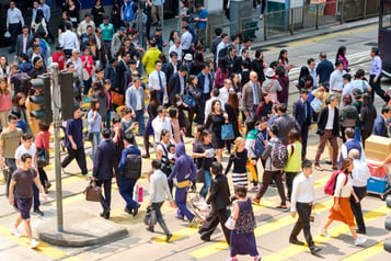 Image of a crosswalk filled with many people walking.