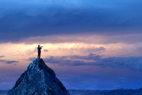 Homme regardant à travers un télescope sur une montagne.