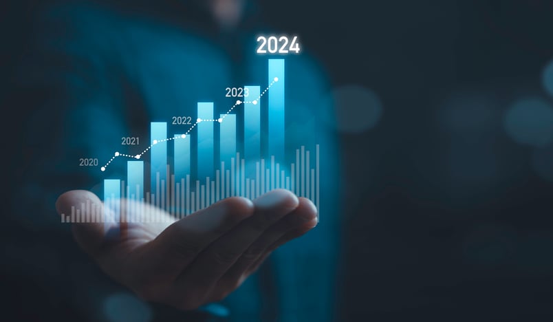 Hand holding a bar graph with the year "2024" highlighted.