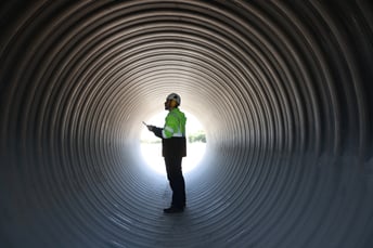 Construction worker in a pipe.