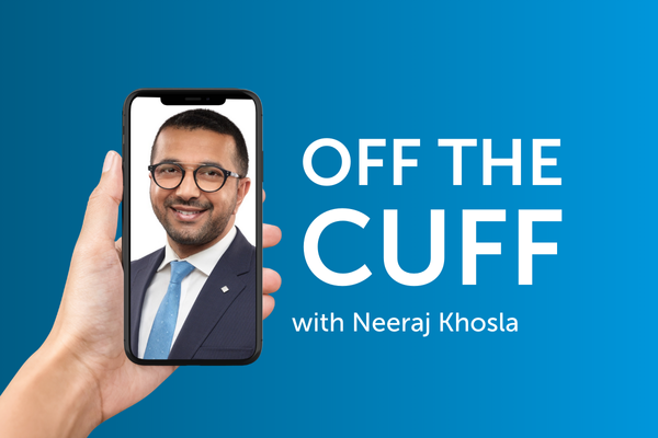 A hand holding a smartphone containing a close-up photo of a businessman next to the text “Off the cuff with Neeraj Khosla”