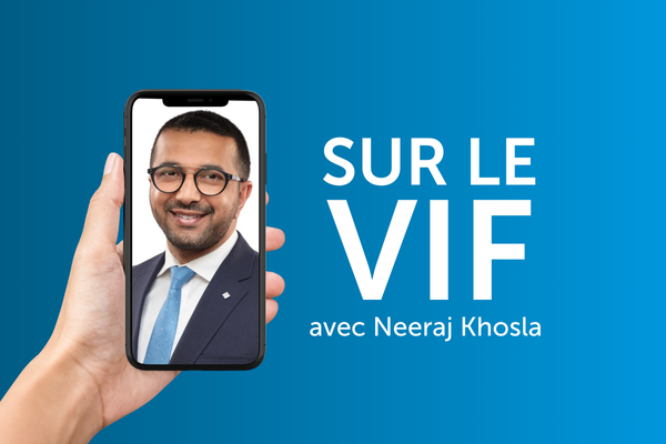 Main qui tient un cellulaire affichant le visage d’un homme d’affaires à côté du texte « Sur le vif avec Neeraj Khosla »