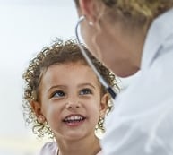 Young child smiling at doctor